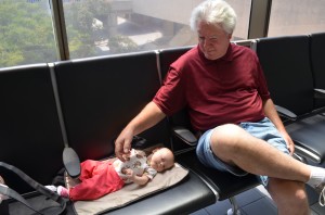 Happier moments from Isla's travels: baggage claim with Grandpa