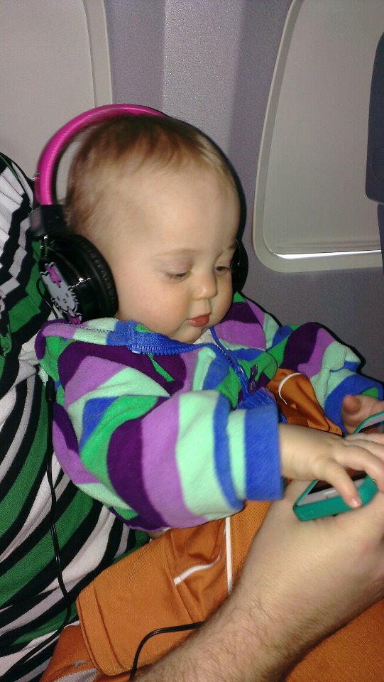 Isla with headphones on plane